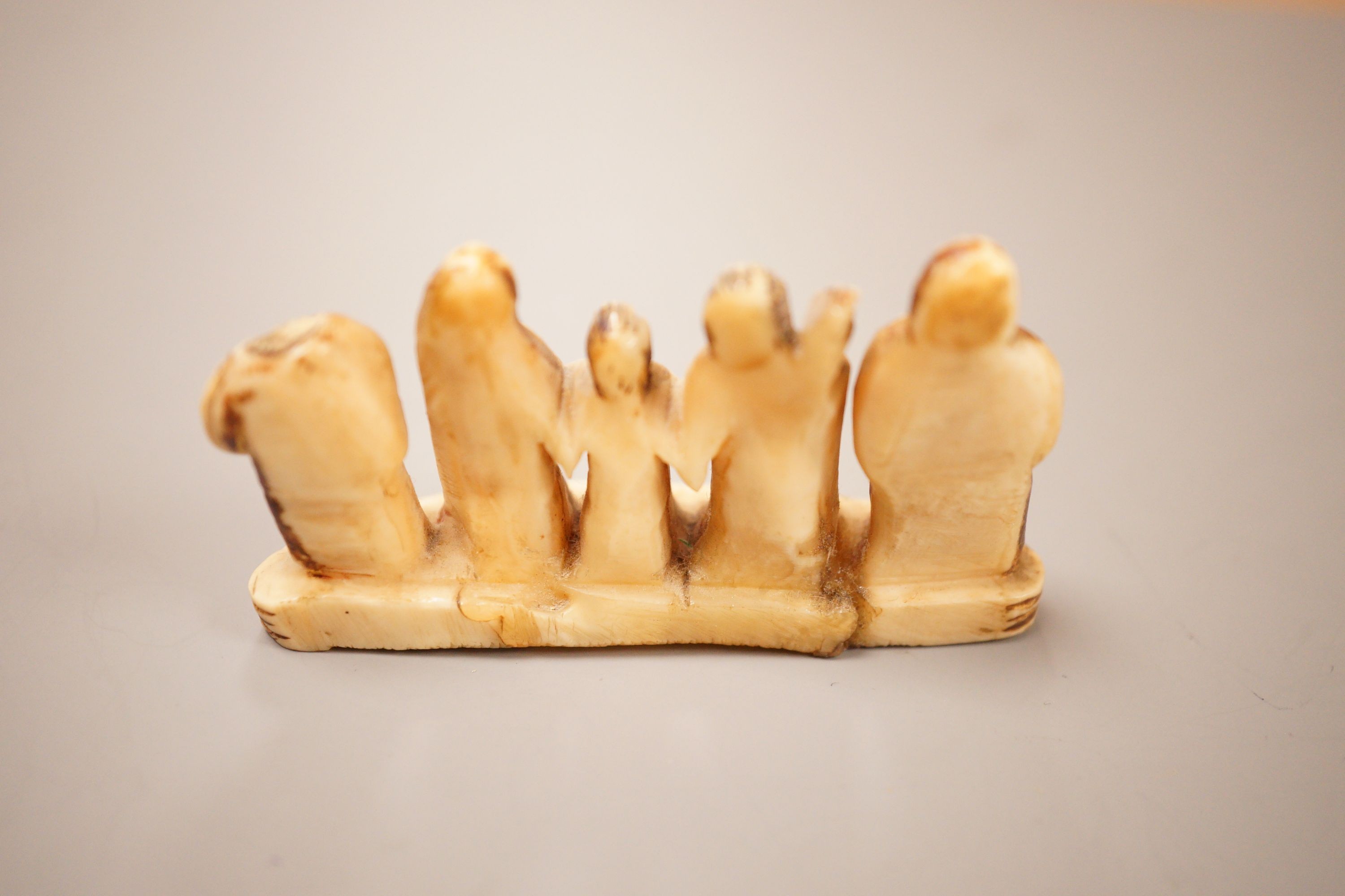 An Inuit whale tooth carving, 19th century, 8cm long, and a marine ivory religious group, possibly Goa